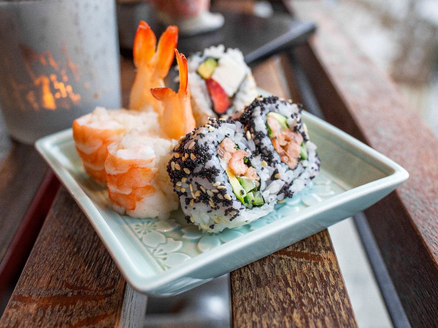 Fancy sushi set with 8 pieces, including shrimp, salmon, avocado and caviar on a plate